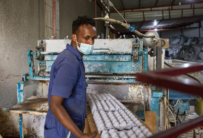 Man in mask with empty egg cartons